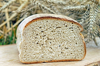 Freshly Baked Sourdough Bread Loaf with Wheat Background