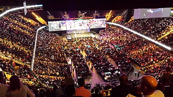 Wide view of crowded indoor arena concert stage