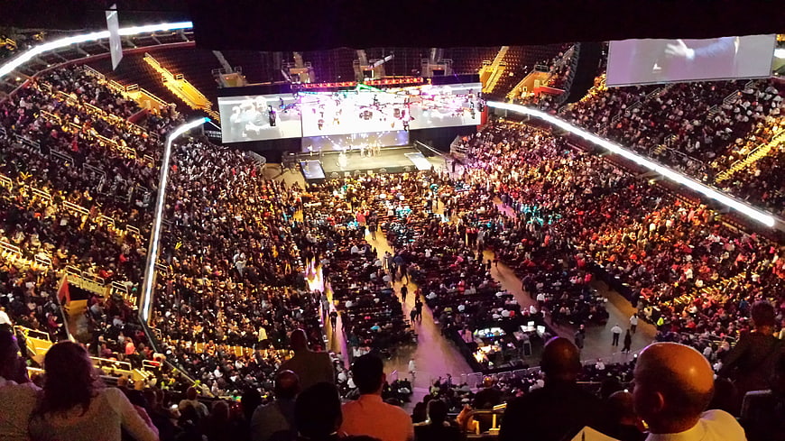 Wide view of crowded indoor arena concert stage