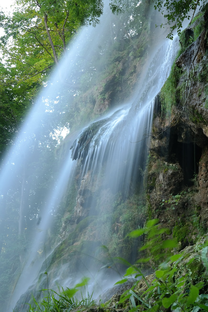Mystical waterfall with long exposure mist in lush forest
