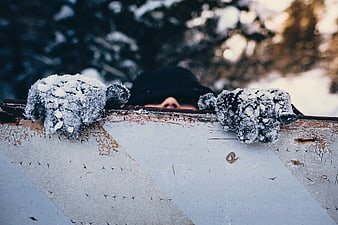 Man in Snowy Gloves Peeking Over Rusty Fence