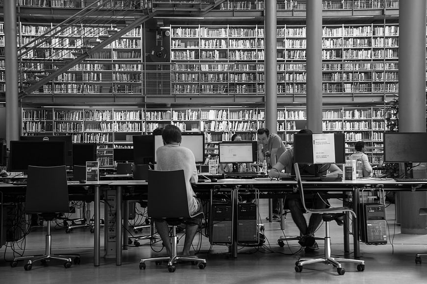 Students studying at computers in a modern university library