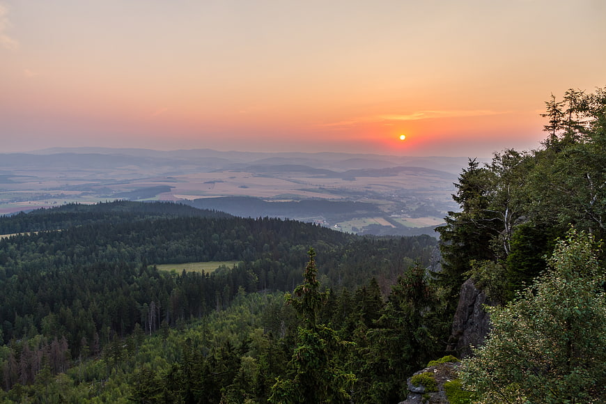 Sunset Over Rolling Hills and Forested Landscape