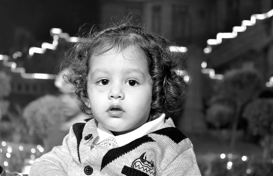 Cute toddler with curly hair in black and white portrait