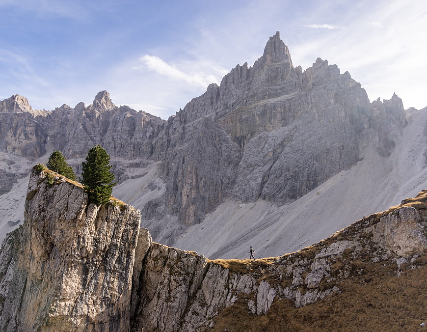 Lone Hiker on Rocky Ridge with Majestic Dolomites Mountain Peak