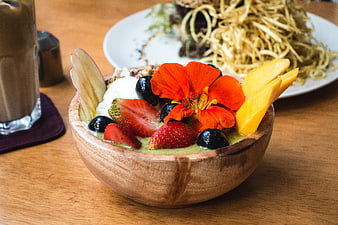 Colorful healthy smoothie bowl with fresh fruits and edible flower
