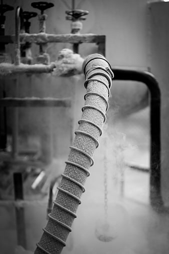 Frosted industrial pipe with steam in black and white