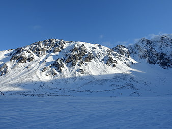 Snow-Covered Mountain Peak Under Clear Blue Sky