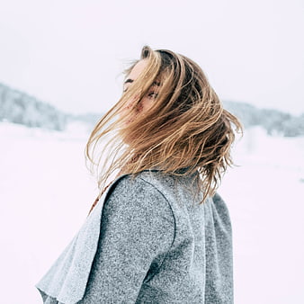 Woman with Windblown Hair in Snowy Winter Landscape