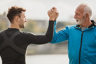 Senior and young man high five outdoors