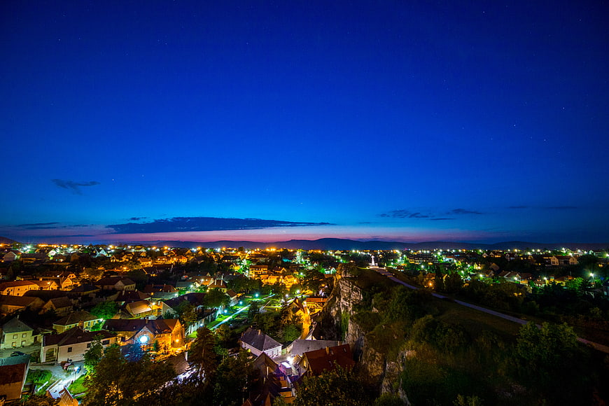 Night cityscape with glowing lights and starry blue sky