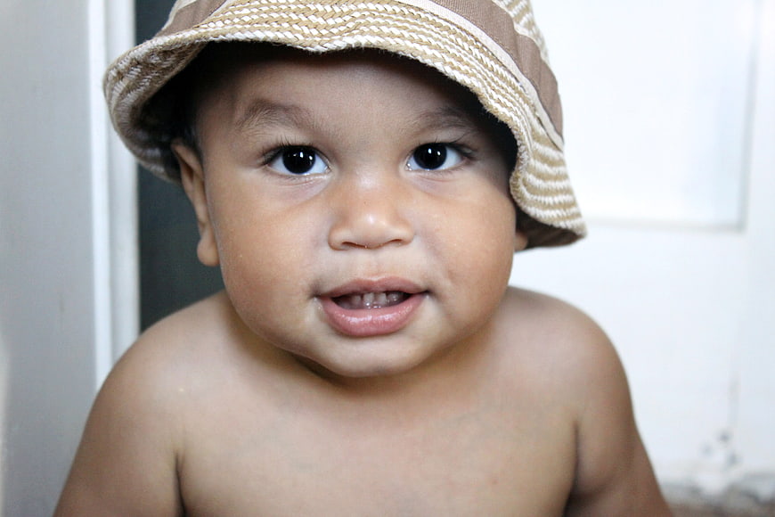 Cute baby boy wearing a striped hat looking at camera