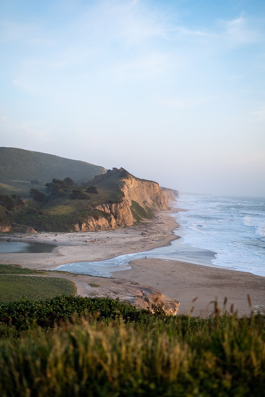 Scenic coastal landscape with cliffs, sandy beach, and ocean waves