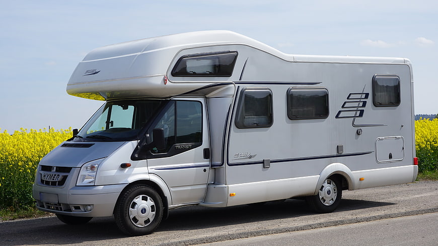 White Hymer Campervan Parked by Yellow Rapeseed Field