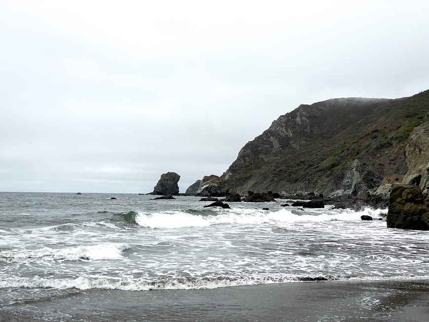 Dramatic Rocky Coastline with Crashing Waves and Overcast Sky