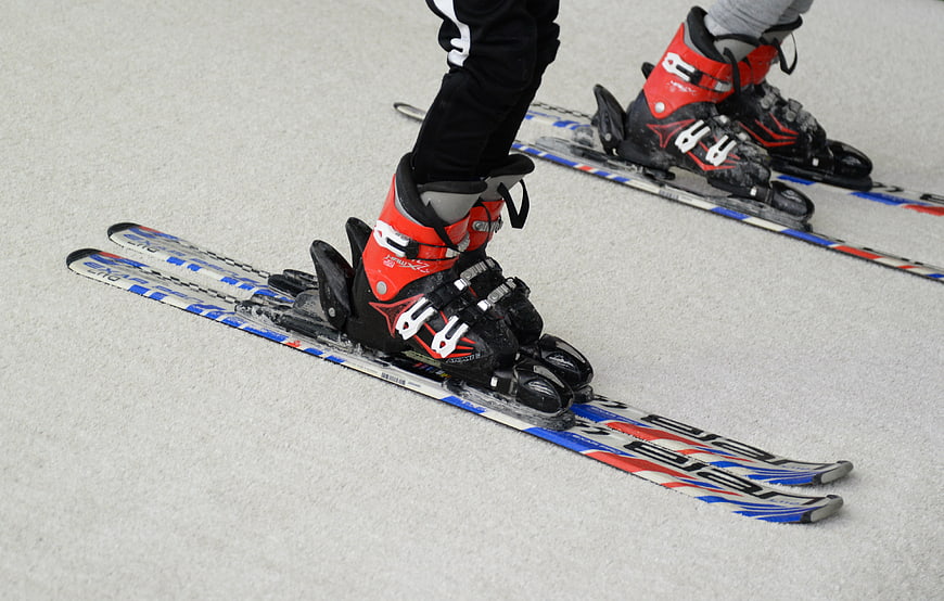 Close-up of red ski boots on skis in snow