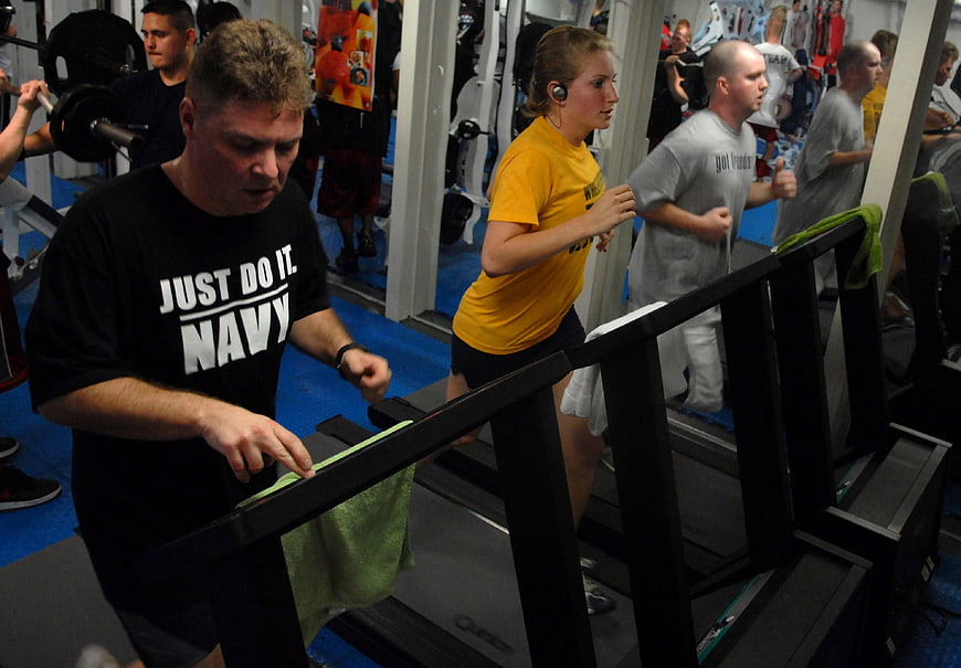 People exercising on treadmills in a busy gym