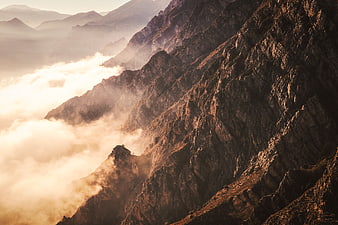 Majestic mountain ridge above sea of clouds at sunrise