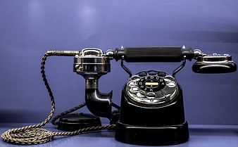 Vintage black rotary telephone on blue background