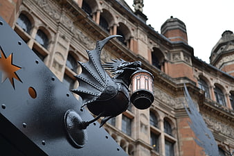 Black Iron Dragon Lantern Sign Against Historic London Theater Facade