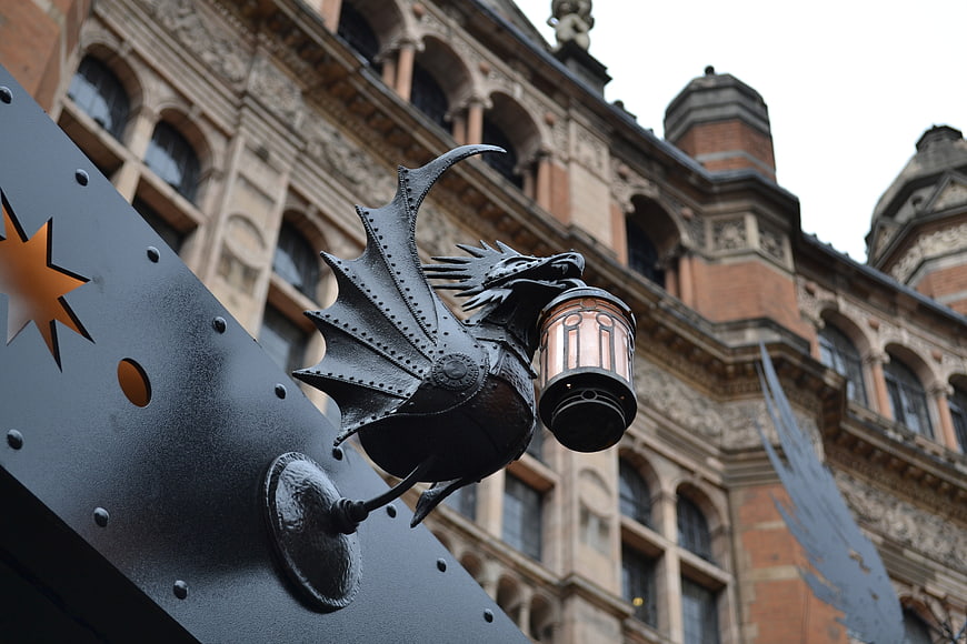 Black Iron Dragon Lantern Sign Against Historic London Theater Facade
