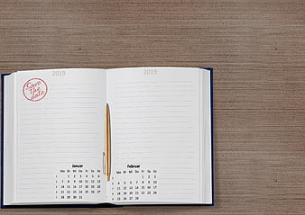 Open 2019 Planner With Save The Date Stamp And Gold Pen On Wood