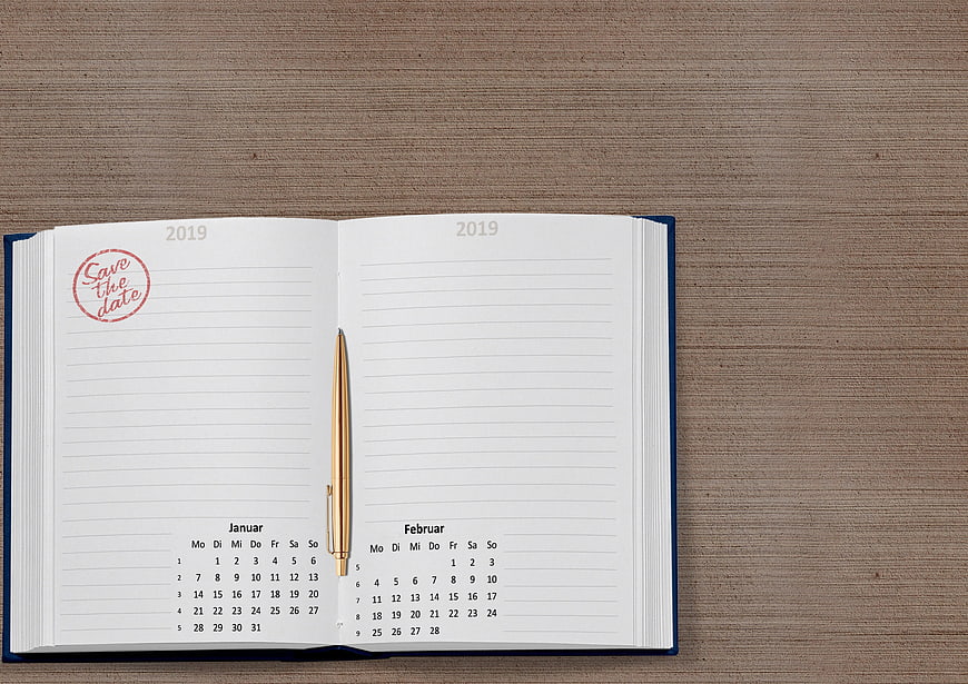 Open 2019 Planner With Save The Date Stamp And Gold Pen On Wood
