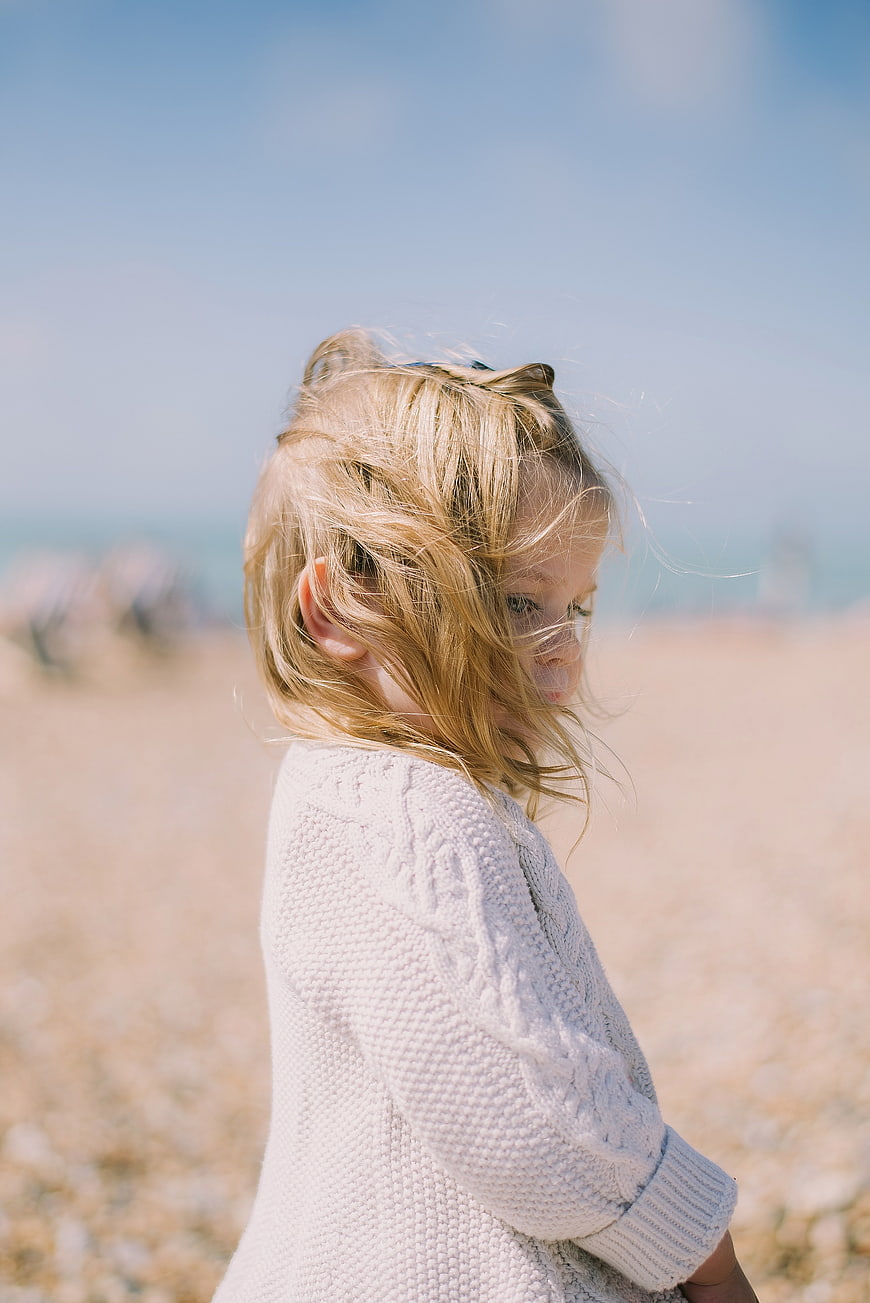 Candid Portrait of Young Girl with Windblown Hair on Beach