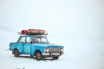Vintage Blue Car in Snowy Landscape