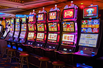 Row of illuminated slot machines in a modern casino gaming floor