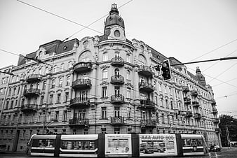 Black and white tram passing historic architecture in Brno