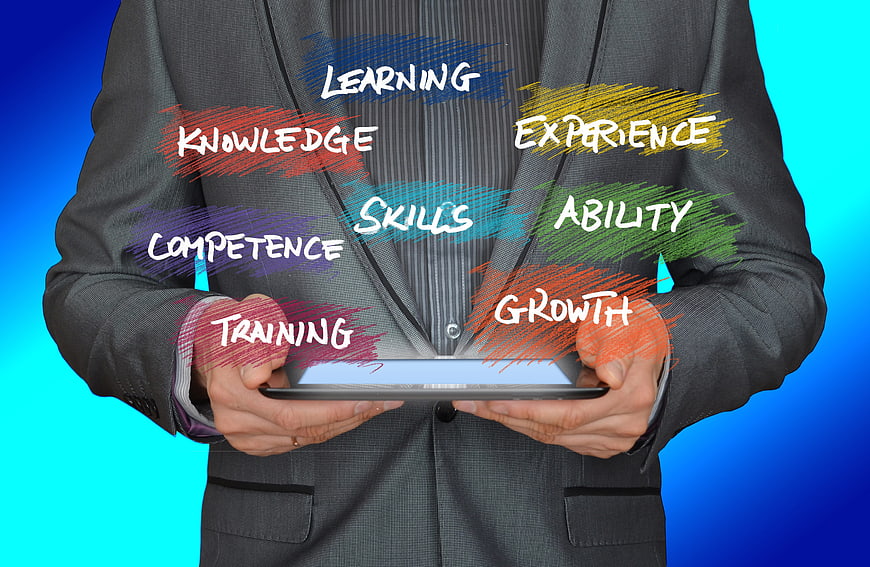 Businessman holding tablet with learning and skills concept