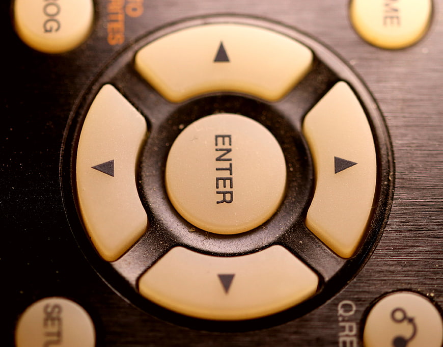 Close-up of vintage remote control directional pad and enter button