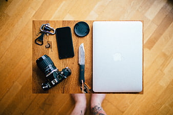 Flat lay of camera, laptop, and knife on wooden board