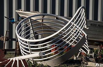 White Spiral Metal Sculpture in Front of Striped Wall