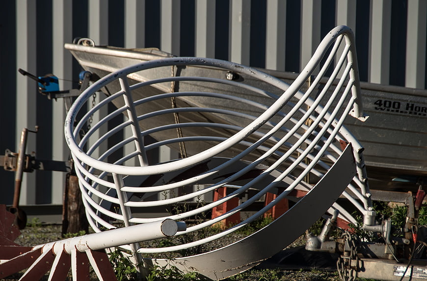 White Spiral Metal Sculpture in Front of Striped Wall