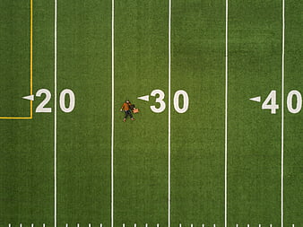 Aerial view of two people walking on a football field