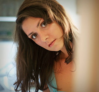 Close-up portrait of a woman looking through a gap
