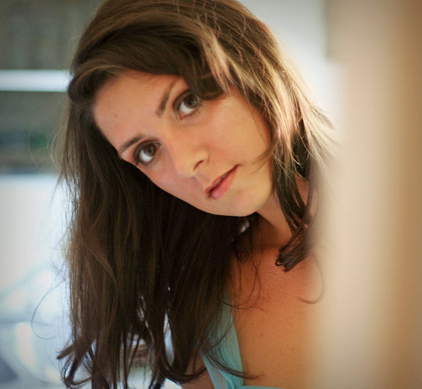 Close-up portrait of a woman looking through a gap