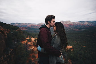 Couple embracing and kissing on a scenic mountain overlook