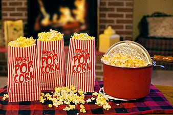 Fresh Popcorn in Red Striped Bags and Pot on Plaid Tablecloth