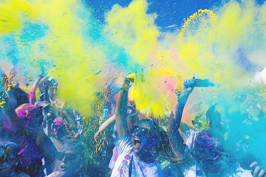 Crowd throwing colorful powder at Holi festival celebration