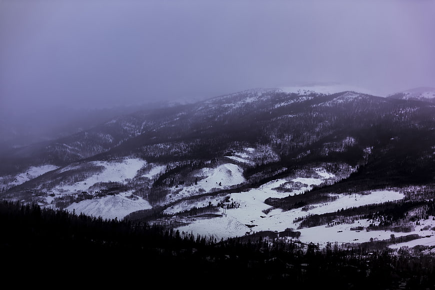 Misty Snow-Covered Mountain Landscape with Dark Forest