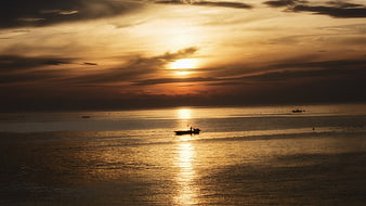 Silhouette of Fishing Boat on Golden Sunset Ocean