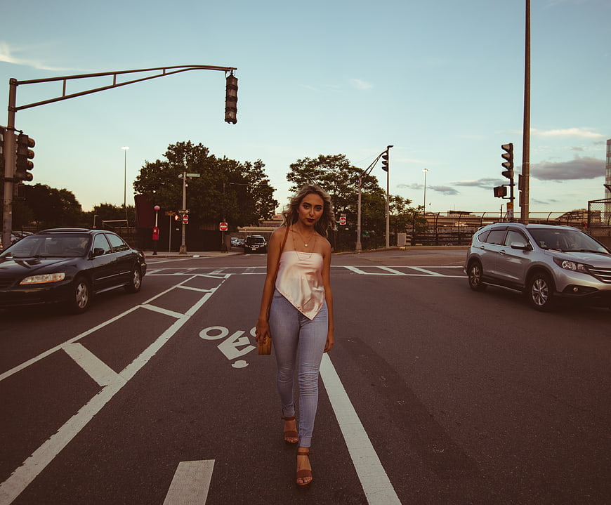 Woman Walking Down Urban Street at Sunset