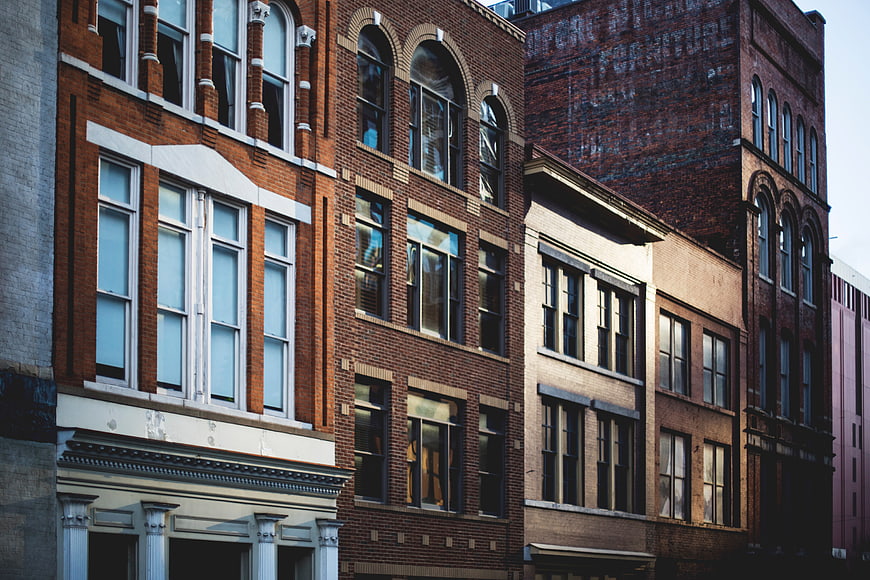 Historic Brick Row Houses with Arched Windows and Faded Ghost Sign