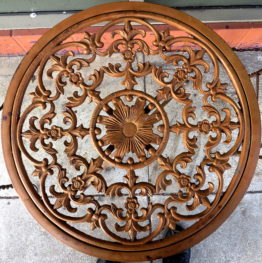 Top view of ornate round metal table with floral pattern