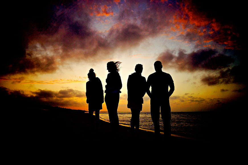 Silhouette of Four Friends Watching Dramatic Sunset at Beach
