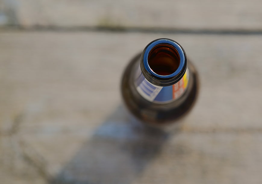 Top View of Open Amber Beer Bottle on Concrete