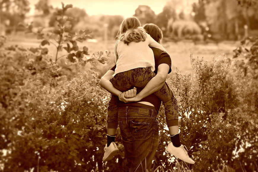 Father Carrying Daughter Piggyback In Field